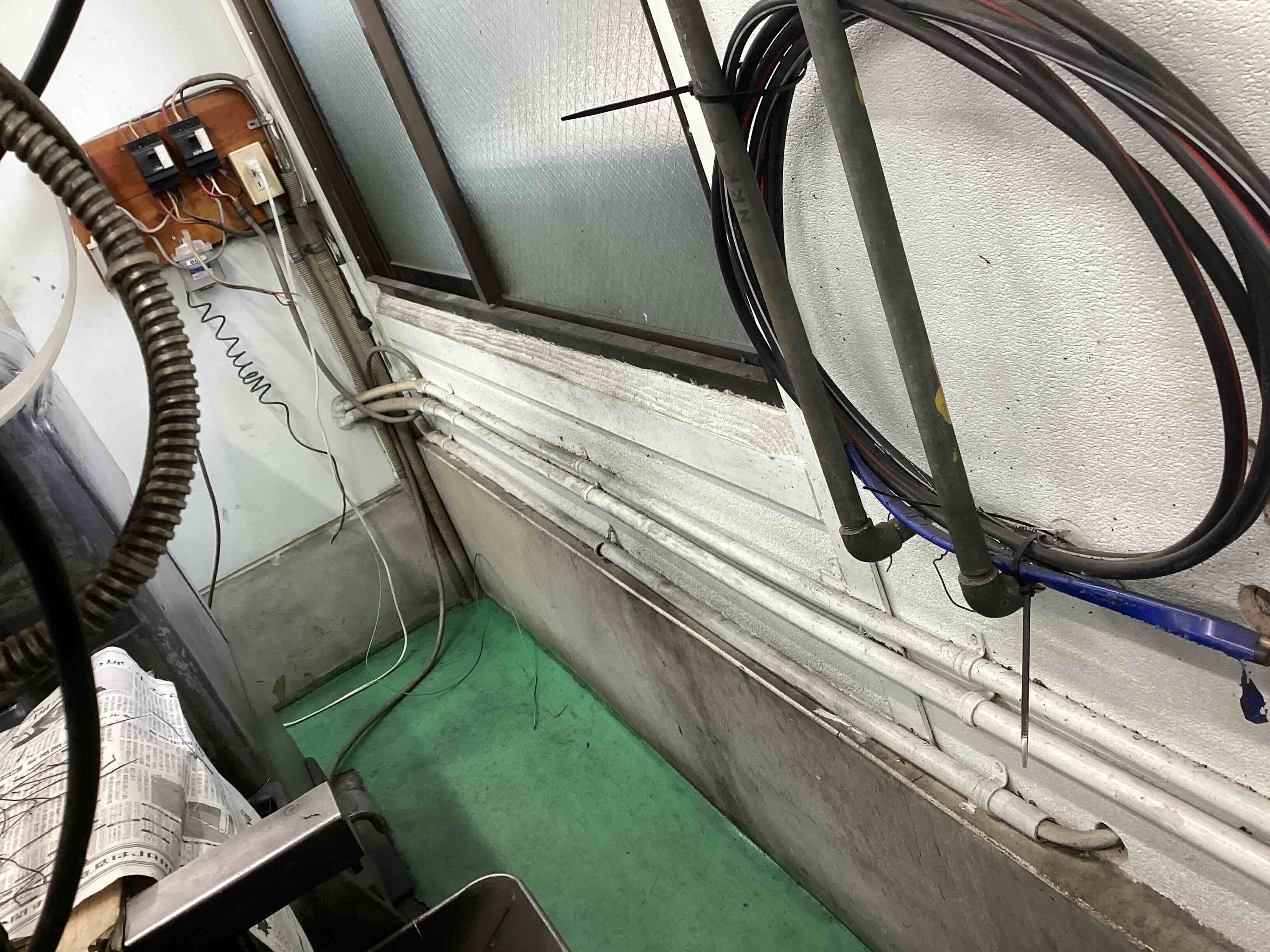 改善前の配管周り。壁と床の隙間や配管の間にキリコなどの汚れが溜まりやすい雑然とした状態。