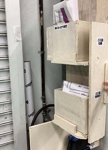 清掃道具置き場のドアを開いてゴミ袋置き場が見えている様子